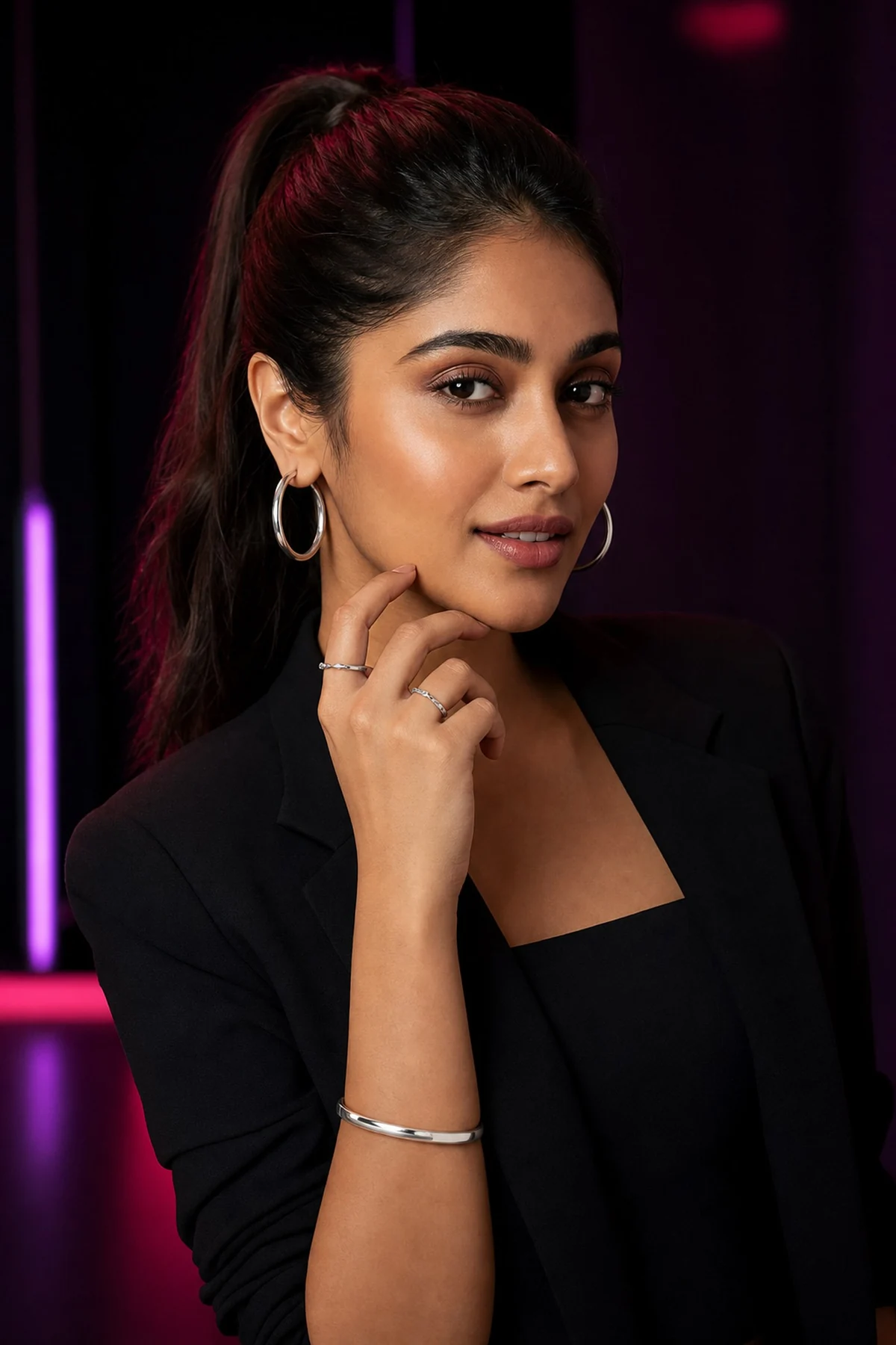 Young Indian model showcasing silver hoops, rings and a cuff bracelet